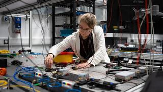 A researcher works on an underwater cable system.