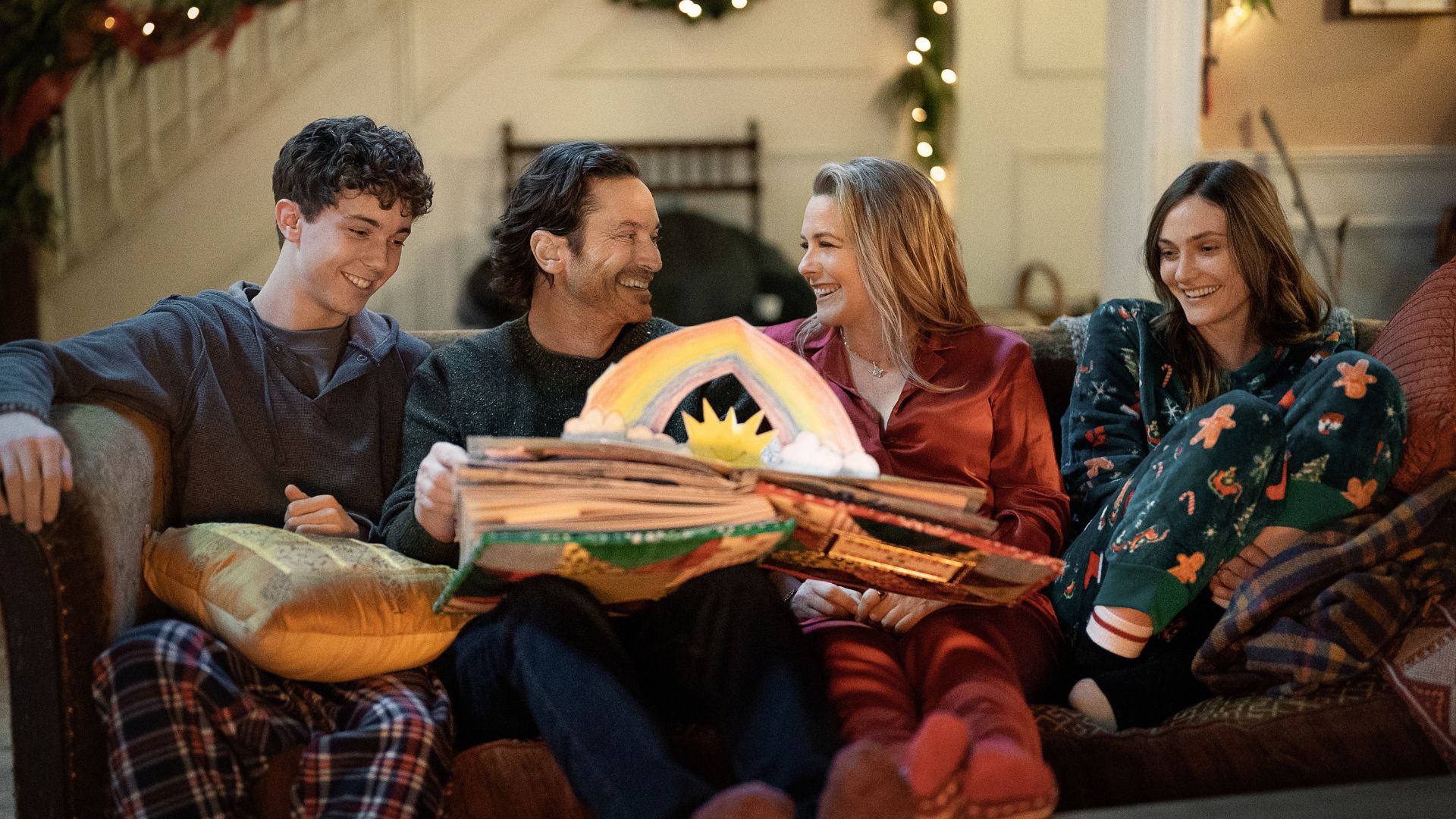 The cast of A Merry Little Ex-mas sit on the couch together