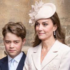 Prince George looks serious while wearing a navy suit and white shirt and has his hair combed to one side