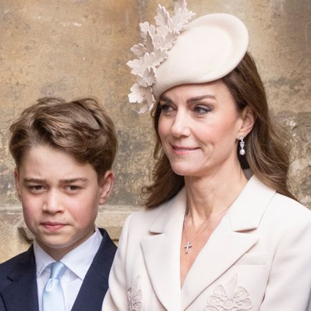 Prince George looks serious while wearing a navy suit and white shirt and has his hair combed to one side