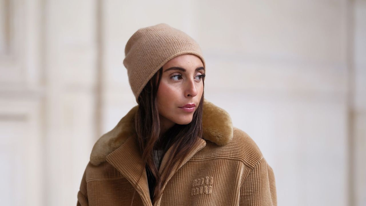 benefit hoola bronzer - woman in beige hat and beige coat looking over her shoulder with warm bronzer skin - gettyimages 1816210836