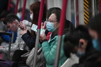 A woman in Hong Kong wears a face mask on the subway.