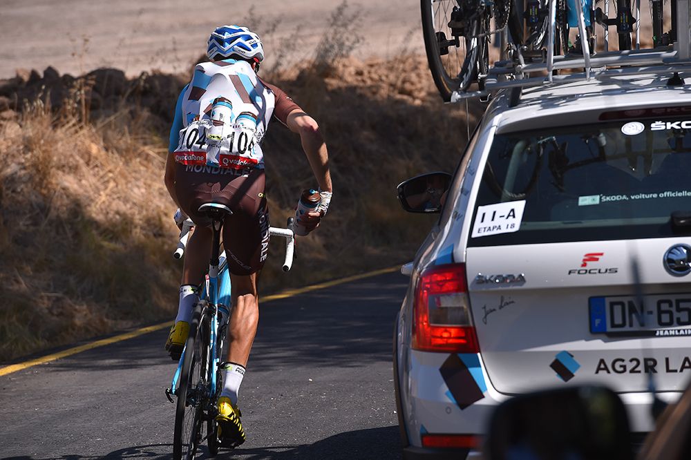 An AG2R rider collects bottles for his teammates during stage 18