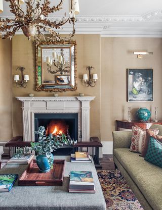 Living room with fireplace, antique chandelier and wall sconce lighting