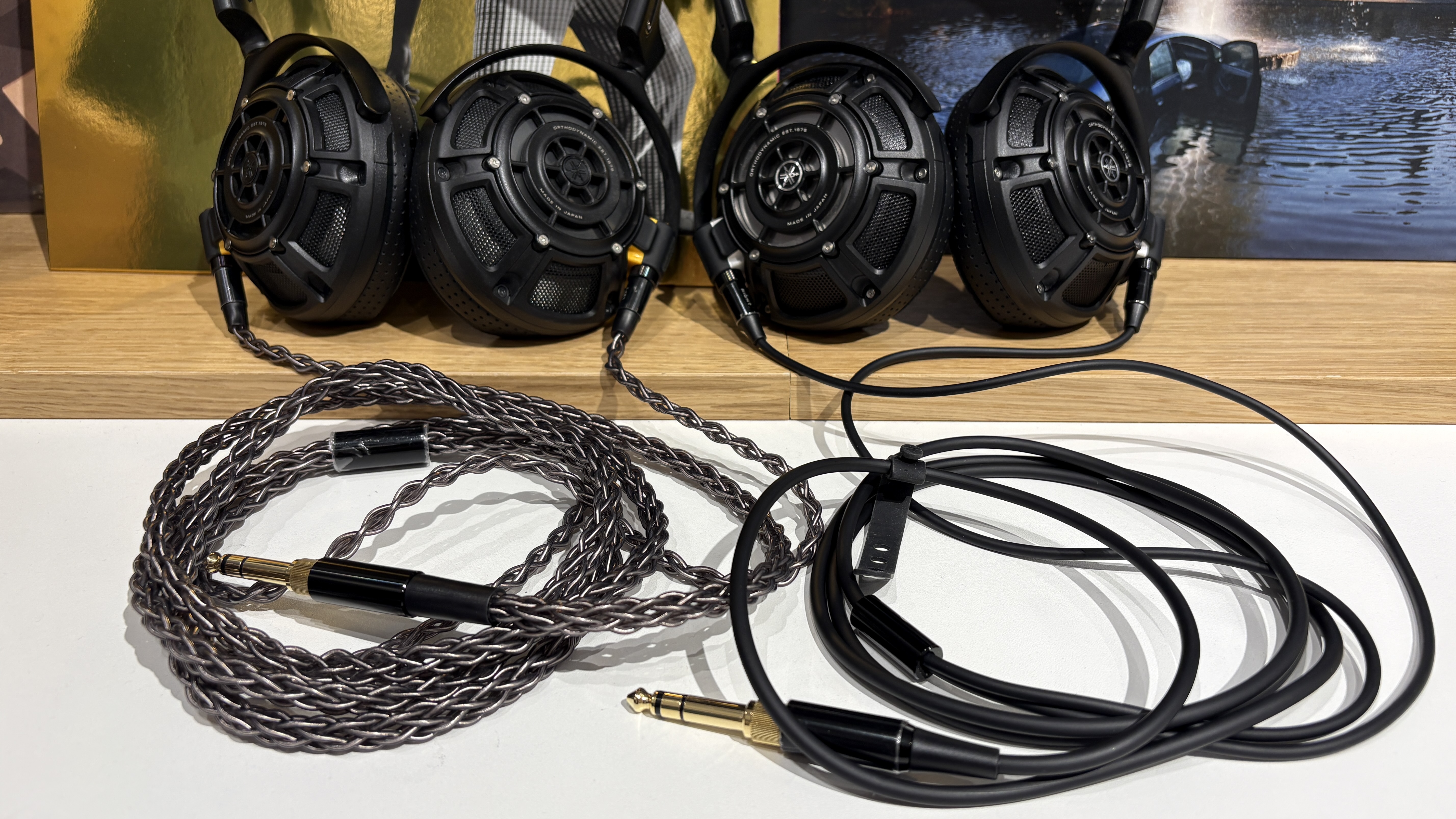 Yamaha YH-5000SE and YH-4000 headphones side-by-side on a desk with vinyl records in background