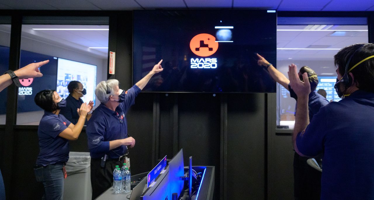 Members of NASA's Perseverance team watch from the mission control room at NASA's Jet Propulsion Laboratory in Pasadena, California, as the first images arrive moments after the rover successfully landed on Mars, on Feb. 18, 2021.