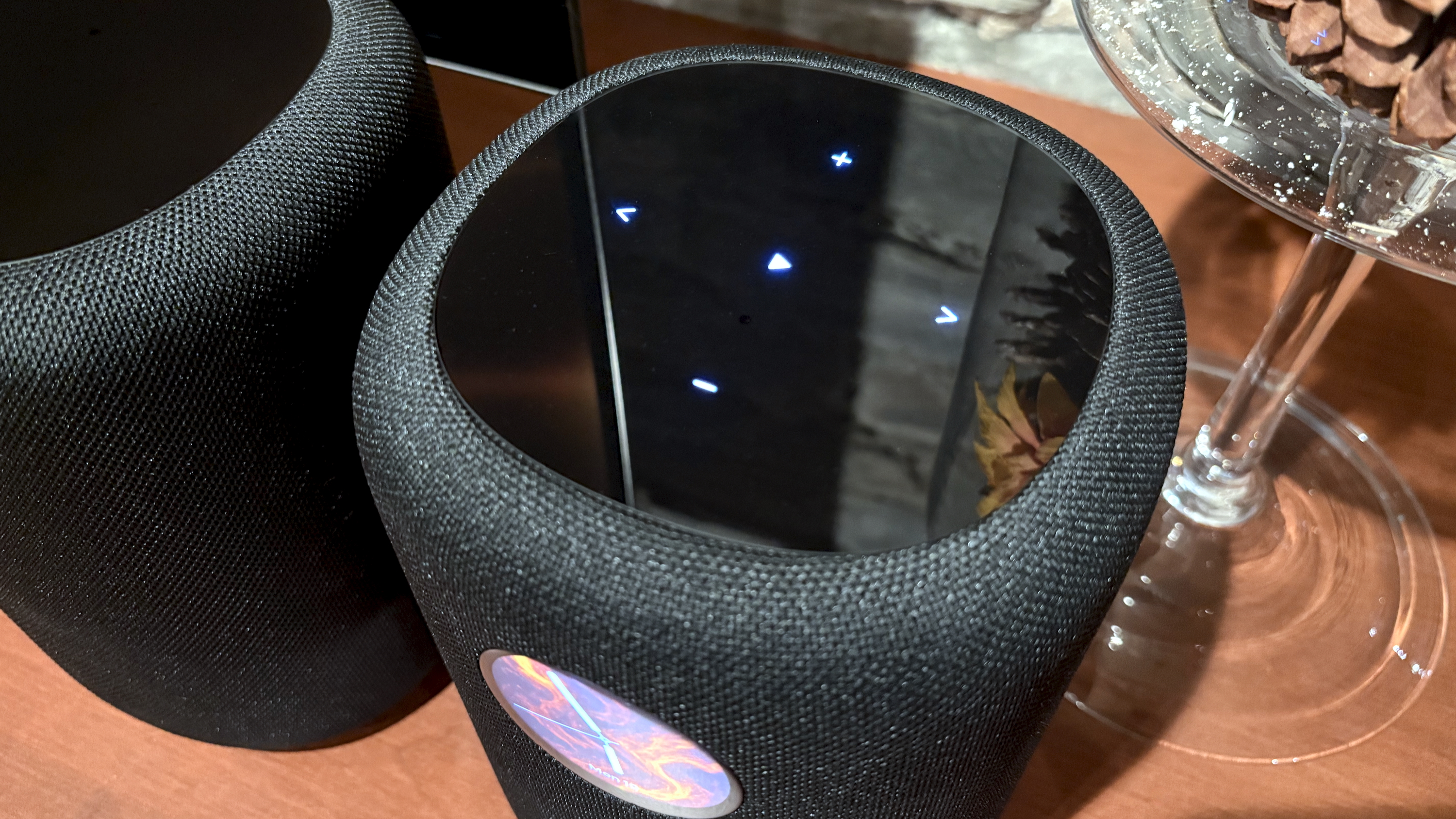 The WiiM Sound, in a home, on a varnished wooden table, showing the illuminated front panel 