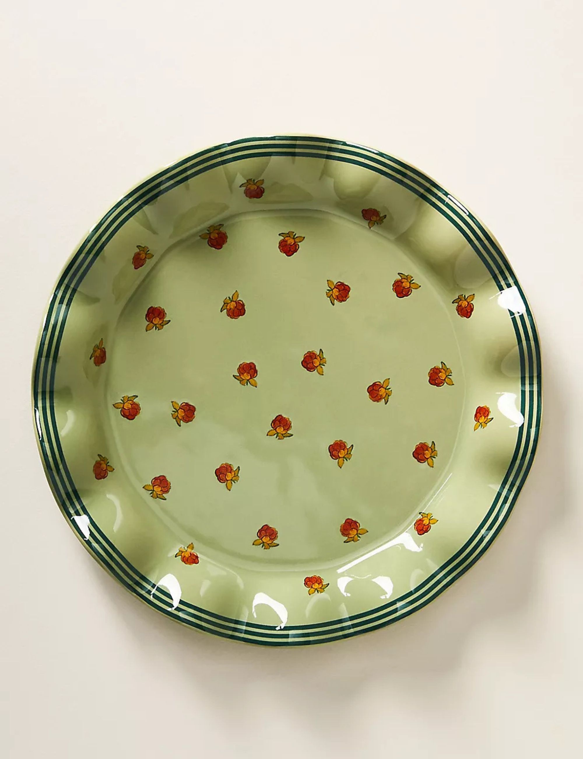 Green plate with ruffled edges and raspberry design