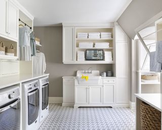 A white laundry room with tiled floors and clothes rail illustrating laundry room storage ideas