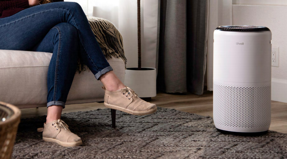 The Levoit Core 400S air purifier in a living room next to a woman's foot.