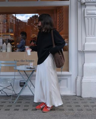 Francesca Saffari wears a maxi skirt with red trainers