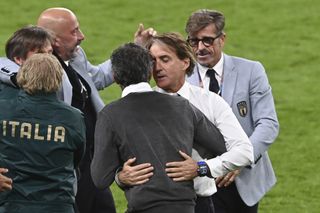 Roberto Mancini, second right, embraces beaten Spain manager Luis Enrique