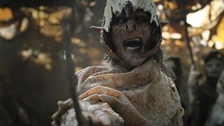 An orc wearing a skull helmet screams right at the camera in The Rings of Power episode 3