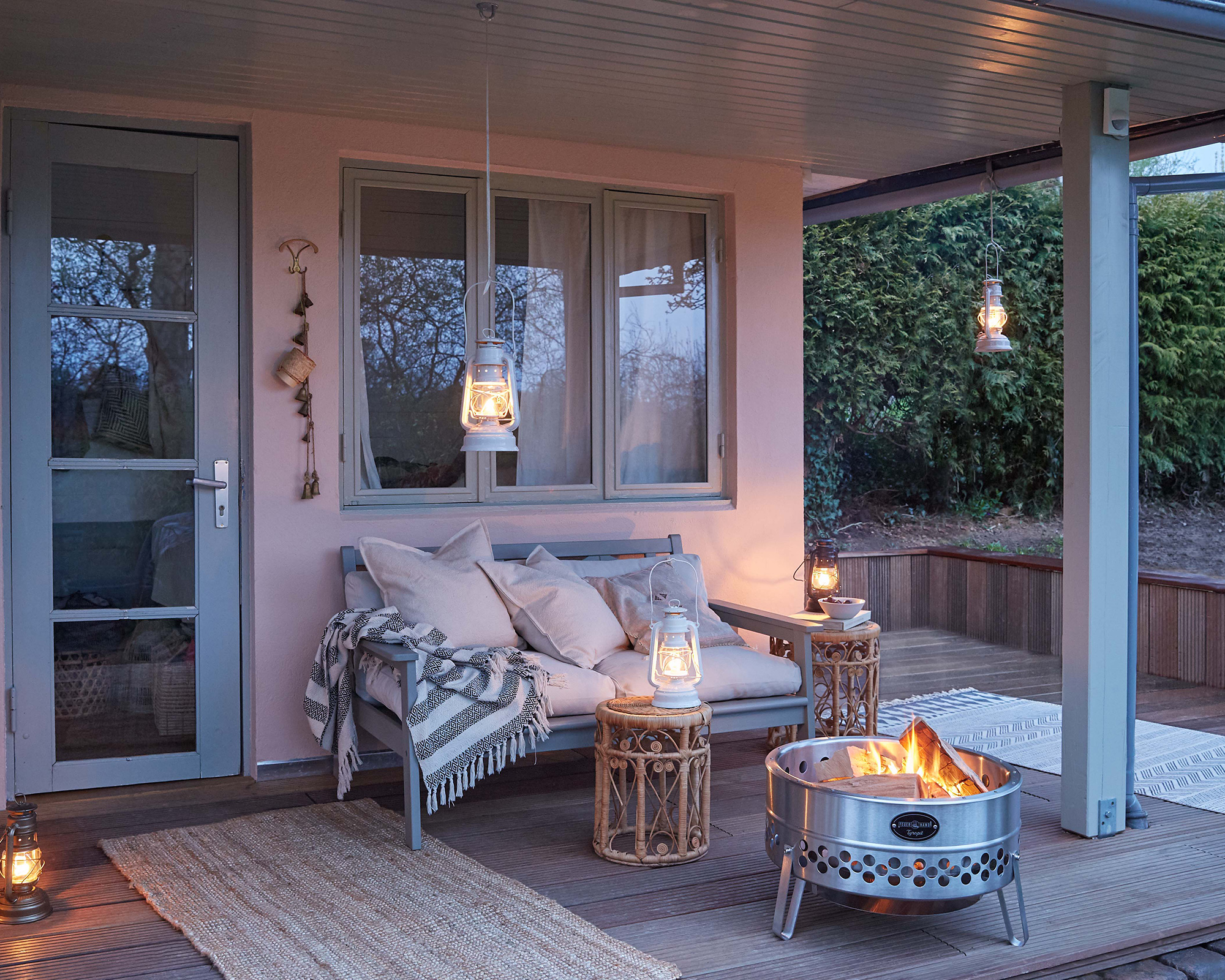A covered patio area with a fire bowl and lanterns