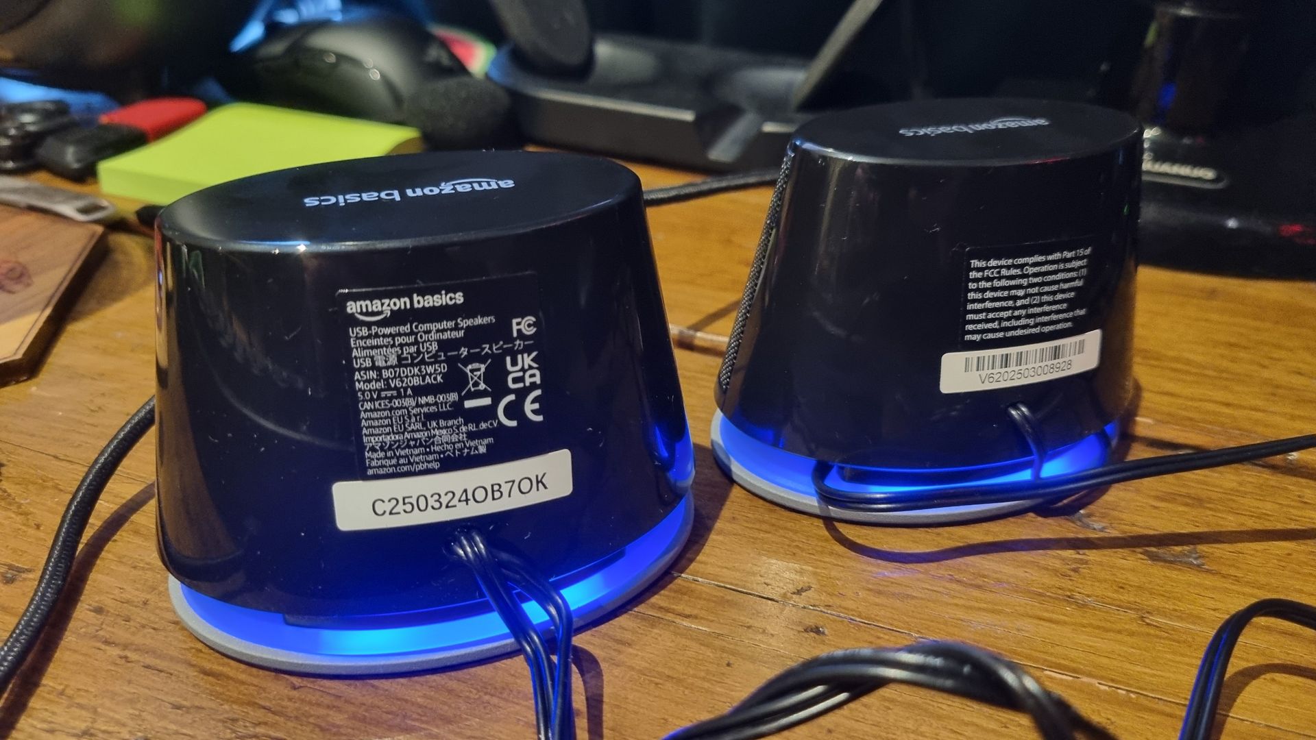 The Amazon Basics Stereo 2.0 speakers on a desktop, shot from various angles