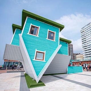 exterior of upside down house one eighty degree flipped with sky blue wall