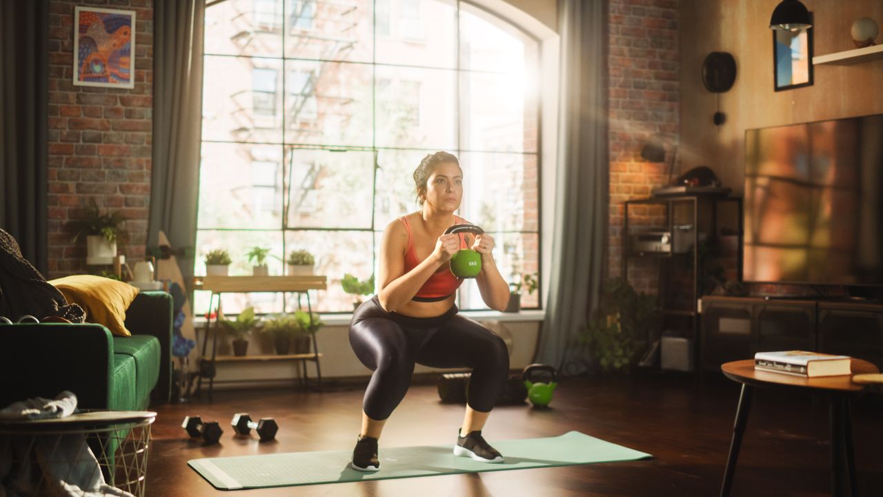 A woman doing a kettlebell workout at home