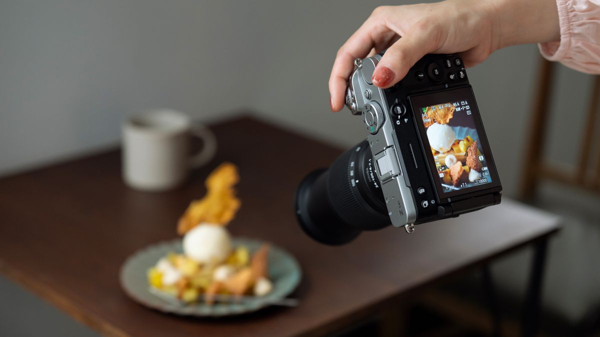 Person taking a photo of a plate of food with the Nikon Z5 II C mirrorless camera