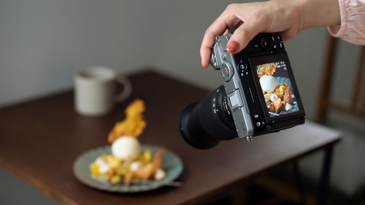 Person taking a photo of a plate of food with the Nikon Z5 II C mirrorless camera