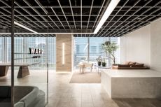 warp studio japanese office with white walls, glass widows and a brown sofa with black table