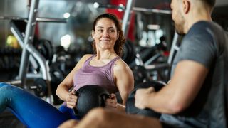 A woman smiles as she does a Russian Twist