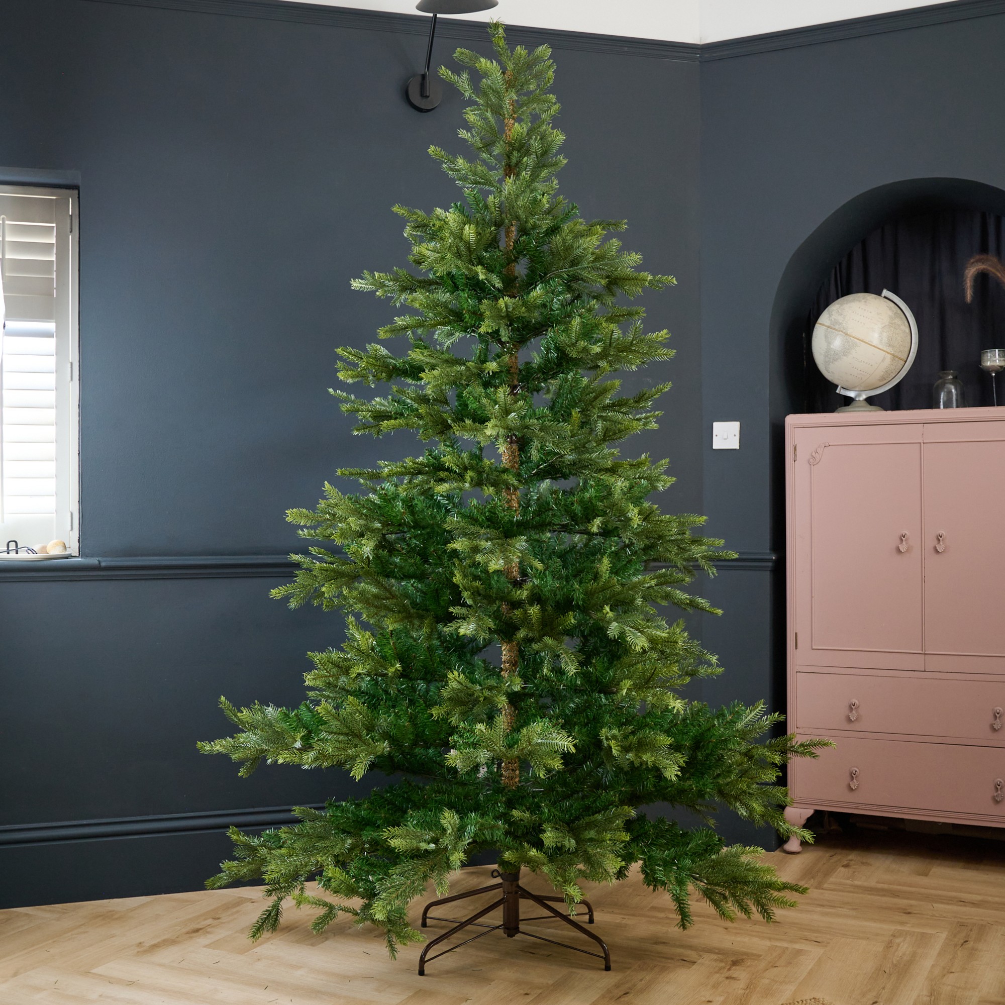 The White Company's 7.5ft Grand Spruce Christmas Tree in a black-painted living room