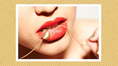 A woman holding a gold heart necklace in her mouth; sex toy jewelry