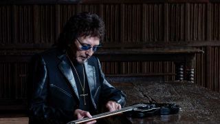 Tony Iommi with guitar in a dark room