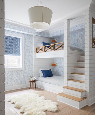 kids bunk room with blue and white wallpaper and staircase to top bunk
