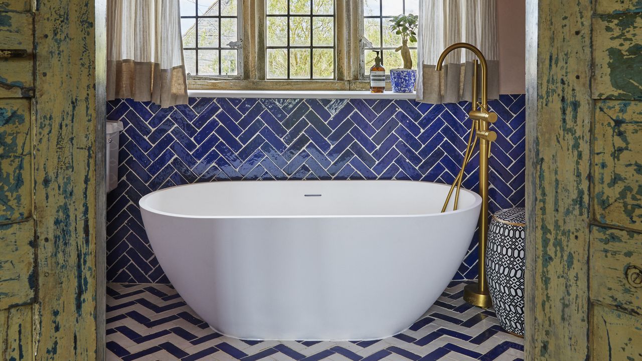 Bathroom with white bath, blue chevron tiles and gold tap