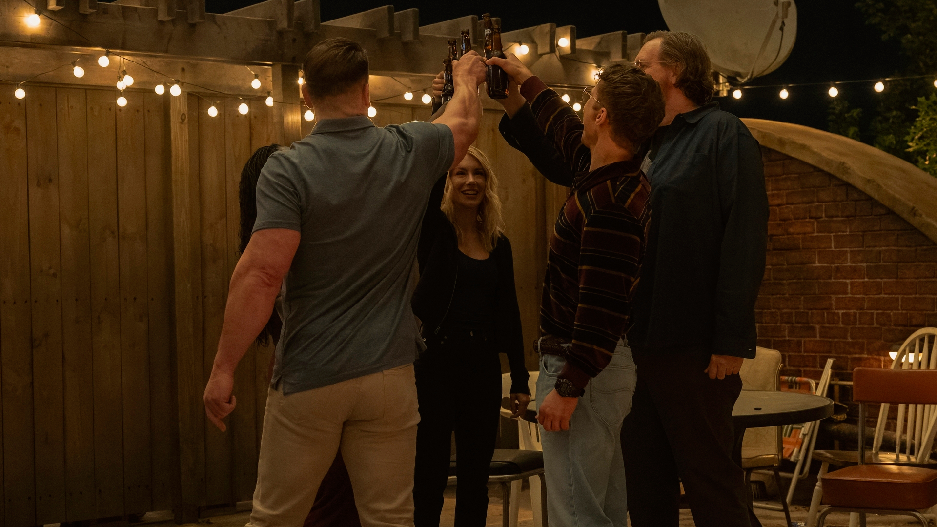 L-R: John Cena, Jennifer Holland, Freddie Stroma and Steve Agee raise a toast in a scene from "Peacemaker" season 2