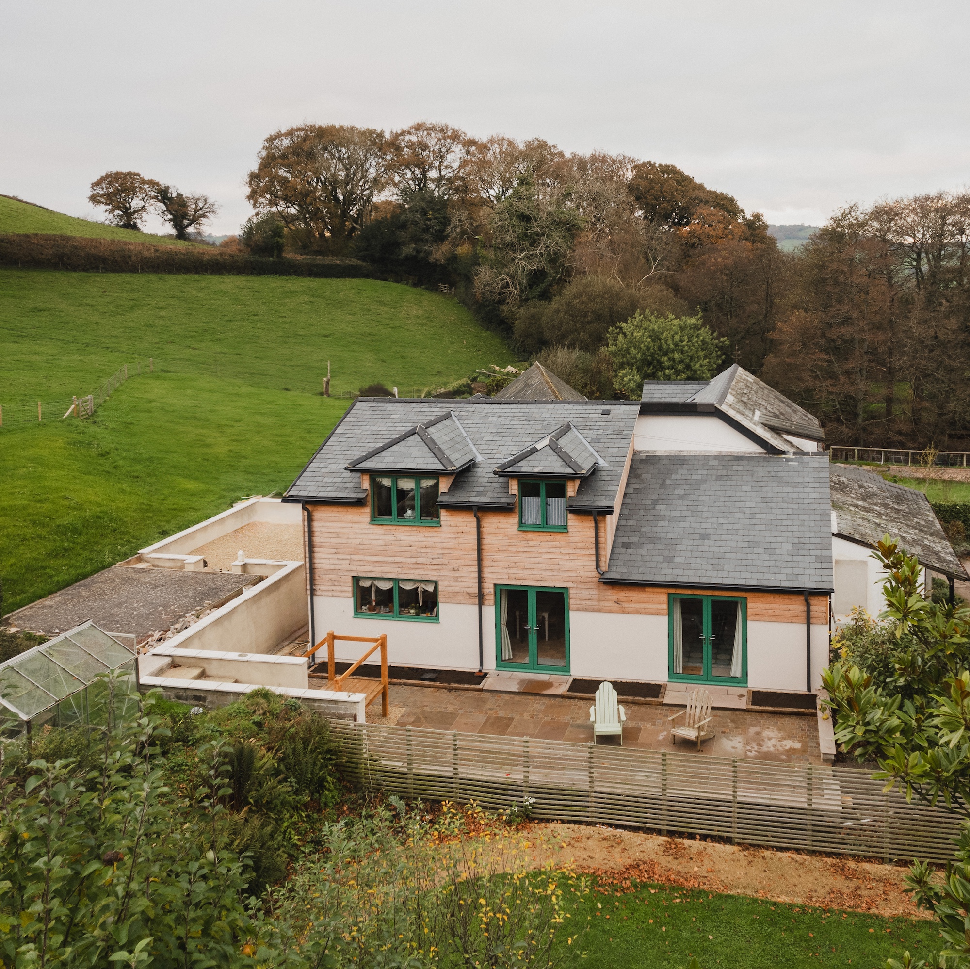 exterior of converted Georgian stables with large two-storey extension with wooden cladding in countryside setting in Devon