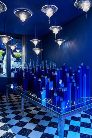 On view at Maison Baccarat was ’An Affair in Blue’, an installation exhibiting the ethereal quality of the new collections. Lots of different glassware arranged of different height blue steps with glass pendant lights hanging above.