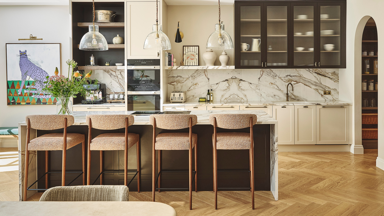 large modern kitchen with an island, bar seating and marble splashback