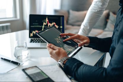 Man looking at an investment chart on tablet