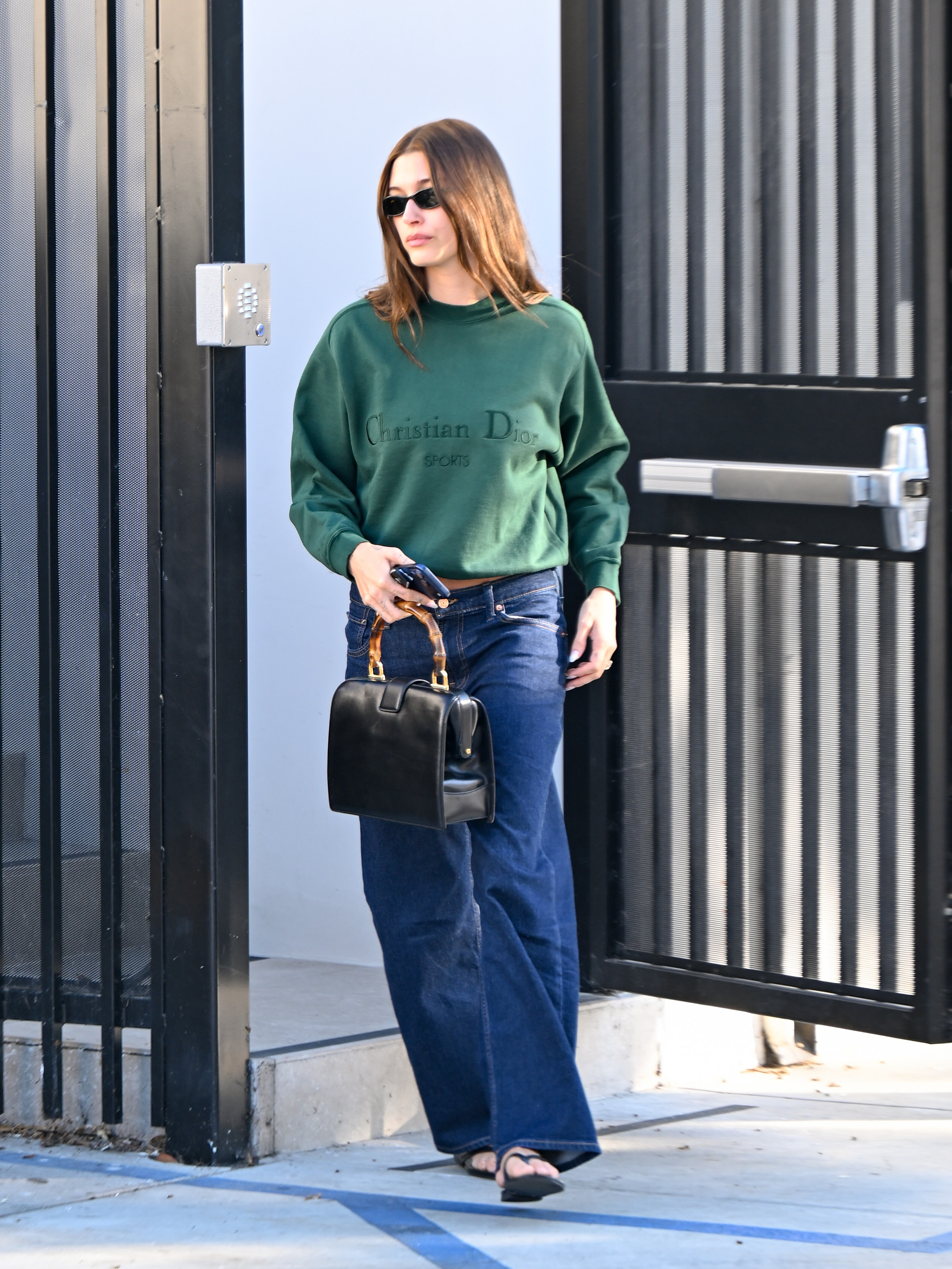 Hailey Bieber styled an oversize Dior sweatshirt with wide-leg jeans and a Dior bowling bag
