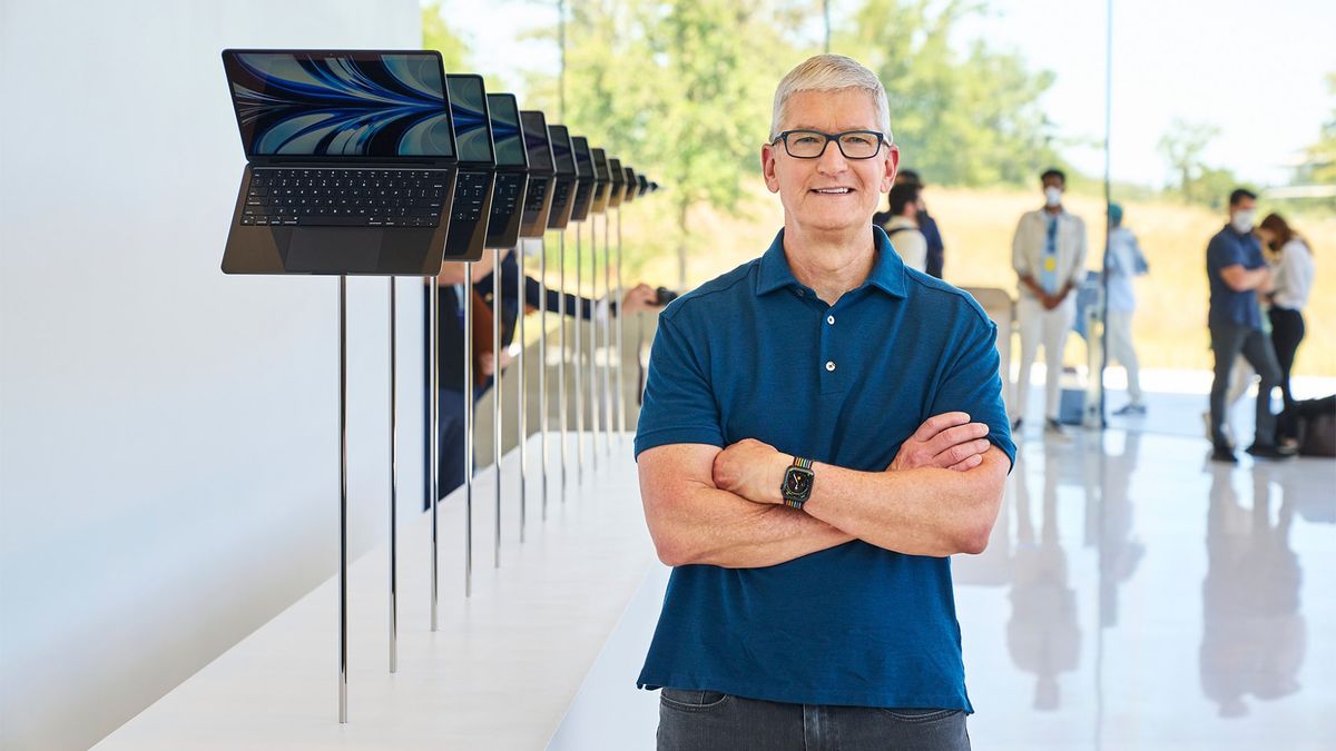 Apple CEO Tim Cook standing next to a row of MacBook Air laptops at the company&#039;s Worldwide Developers Conference (WWDC) in 2022.