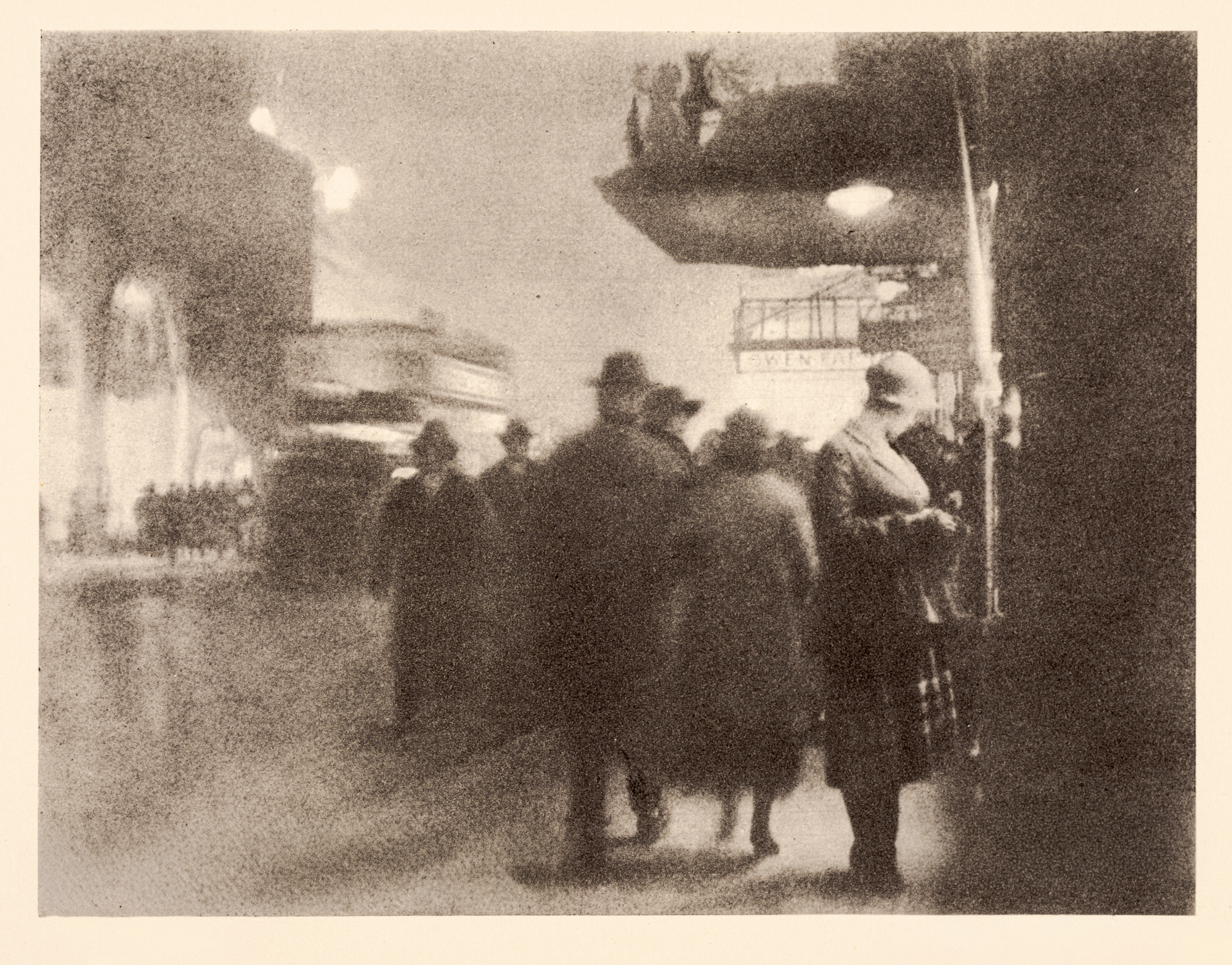 A soft, atmospheric photogravure of a group of pedestrians walking away from the camera at night, past an illuminated shop sign and glowing street lamps.