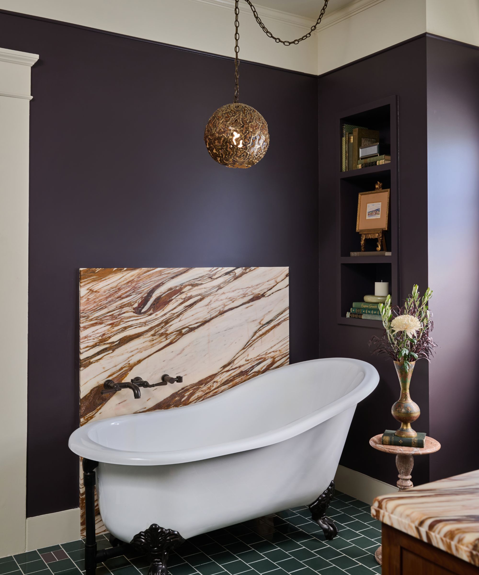 Bathroom with tiled floor, a freestanding white tub with claw feet, French Press Coffee by Dunn-Edwards on the walls, and a built-in bookshelf with books and decor.