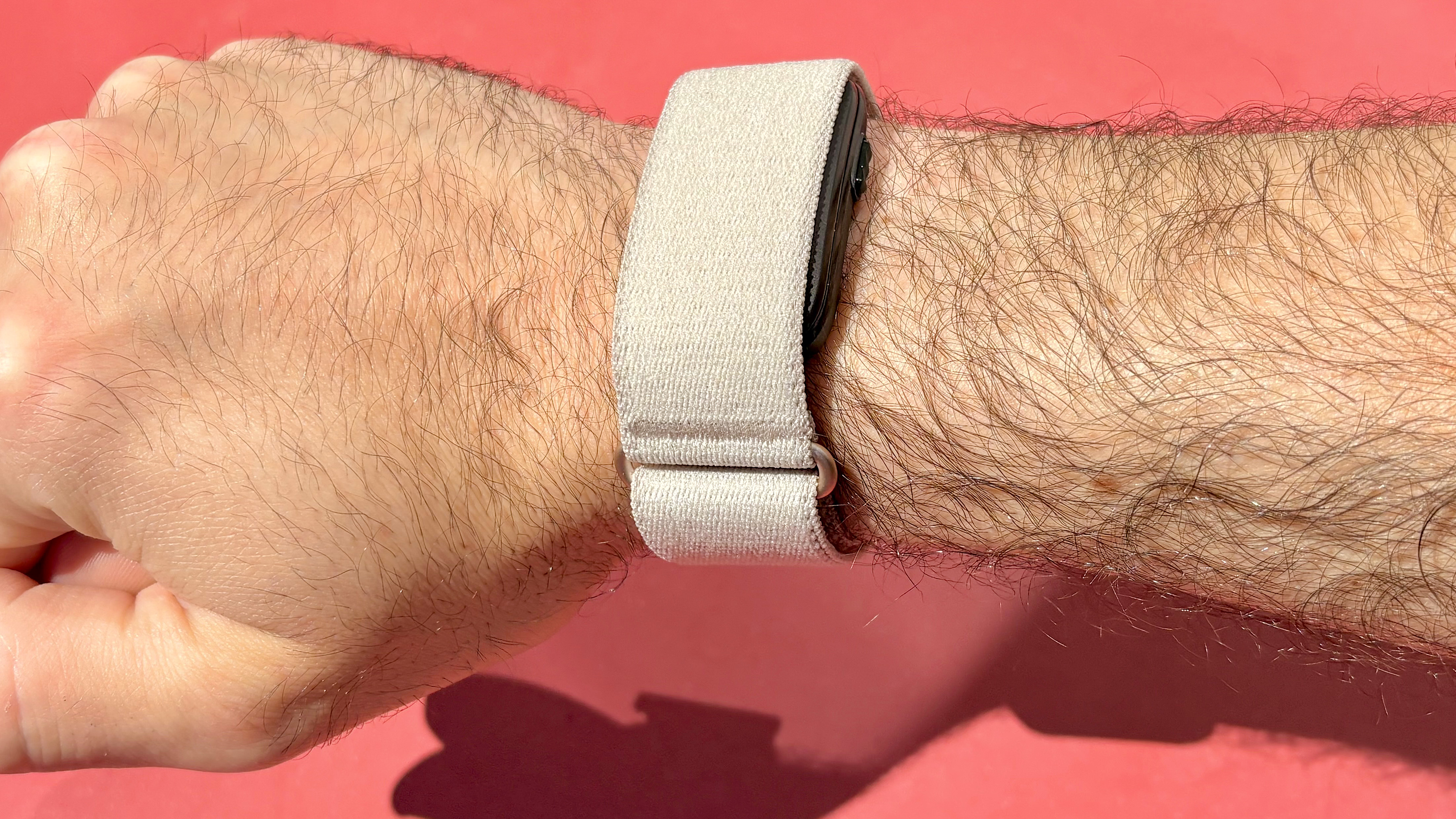 Garmin Cirqa on a user's wrist against a red background