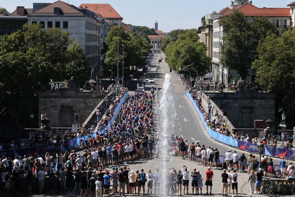 MUNICH GERMANY AUGUST 14 A general view of the peloton passing through Munich streets while fans cheer during the 28th UEC Road Cycling European Championships 2022 Mens Road Race a 2079km one day race from Murnau to Munich EuroRoad22 Munich2022 on August 14 2022 in Munich Germany Photo by Jan HetfleischGetty Images