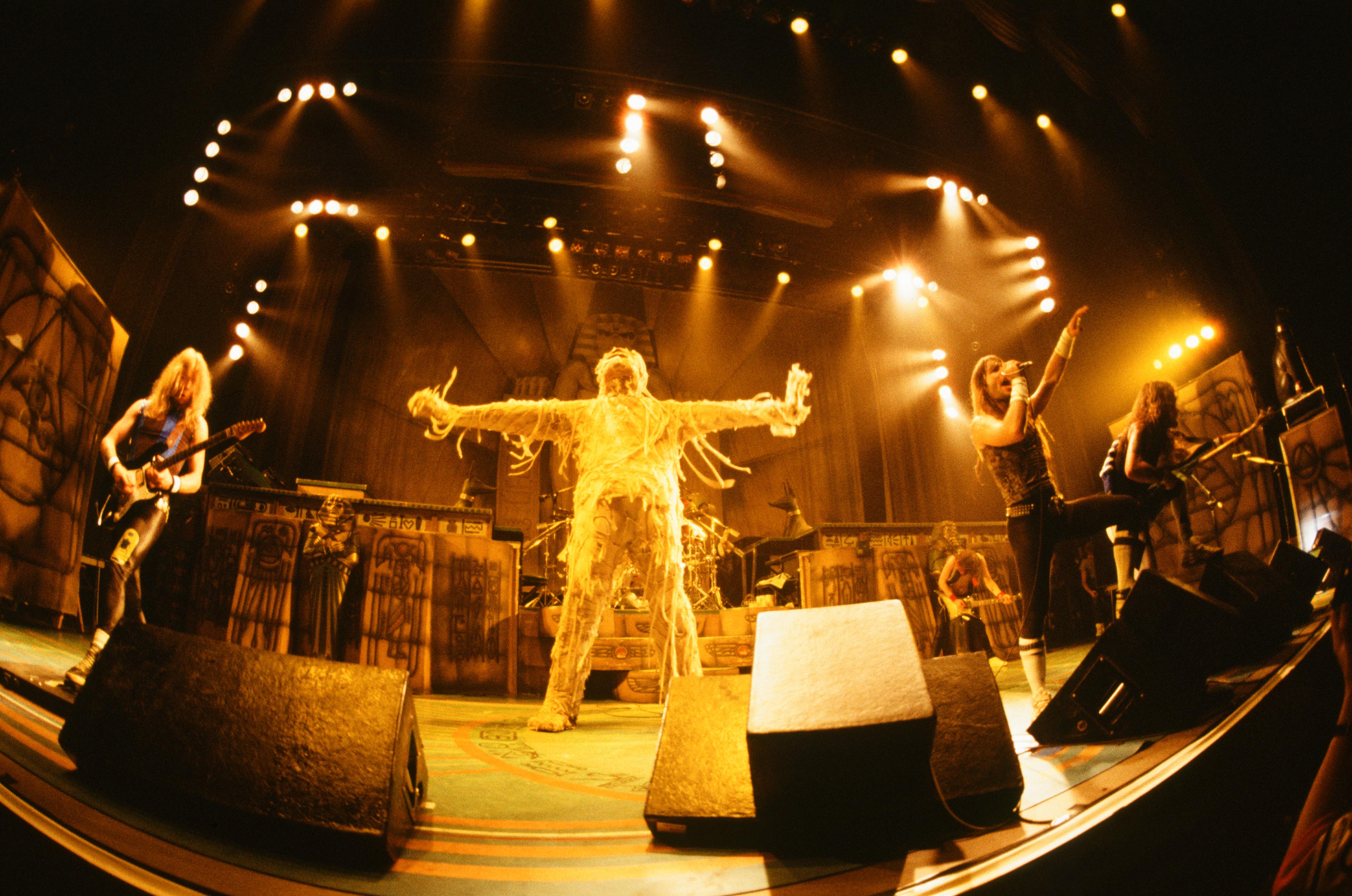Iron Maiden on stage with mummy Eddie posing behind them