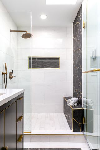 A small guest bathroom shower with a bench