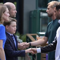 Prince George standing next to Princess Kate and Prince William, shaking hands with Julian Cash and Lloyd Glaspool at Wimbledon