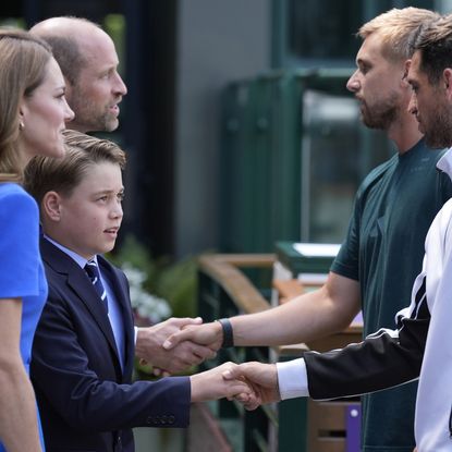 Prince George standing next to Princess Kate and Prince William, shaking hands with Julian Cash and Lloyd Glaspool at Wimbledon
