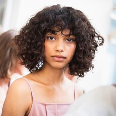 A woman with curly, voluminous hair.