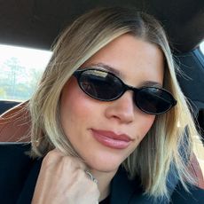 Sofia Grainge woth short, blonde blunt bob haircut and wearing black sunglasses