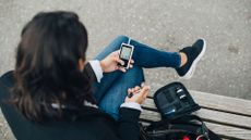 Woman checking blood sugar level while sitting on bench. Maskot via Getty Images