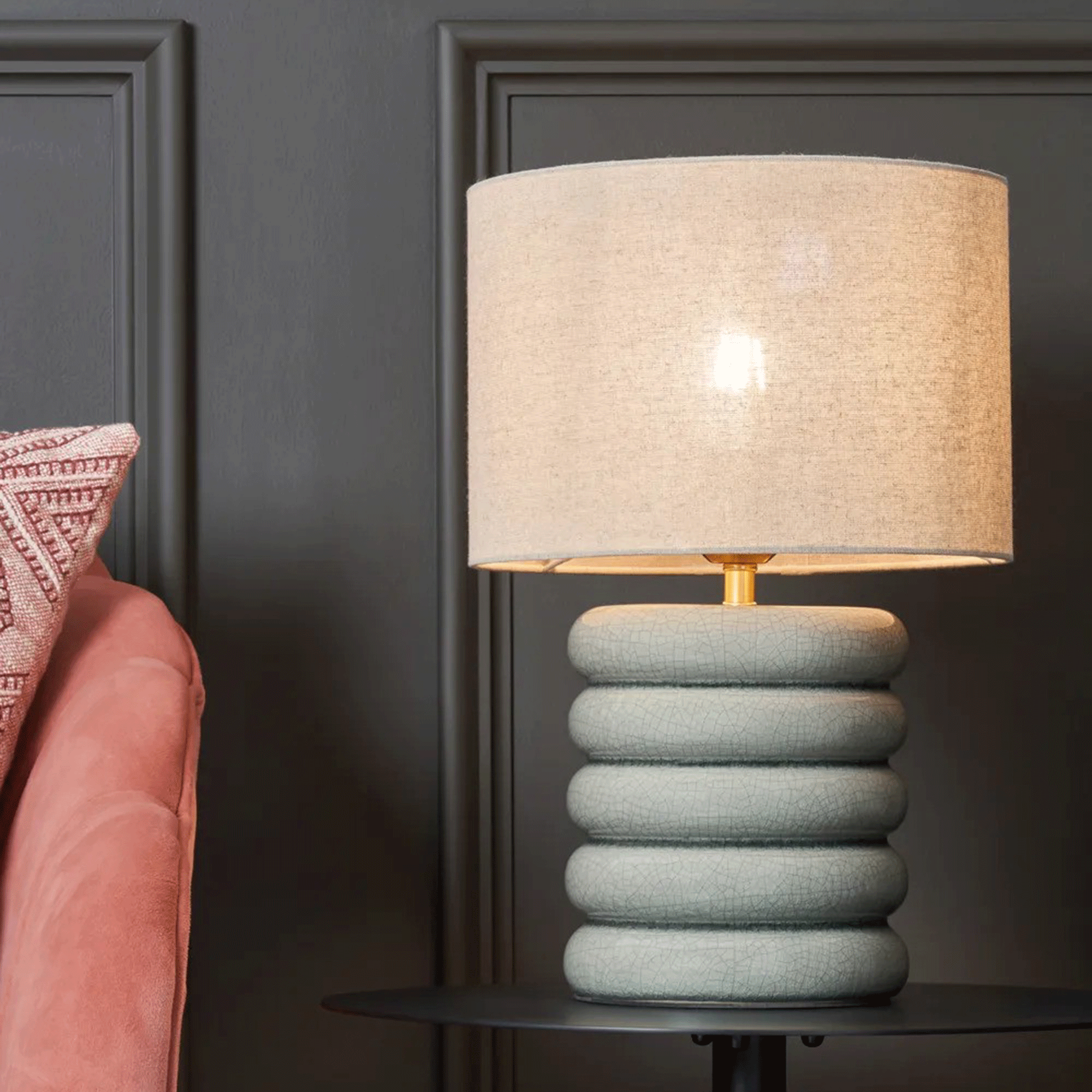 Green ceramic lamp on black side table