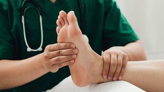 Doctor examining woman's ankle
